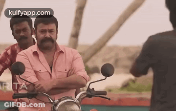 Man With Mustache Riding Motorcycle Beside Two Men GIF