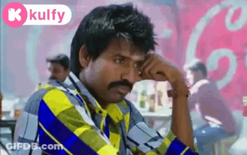 Man With Mustache Sitting In Front Of Coca Cola Sign GIF