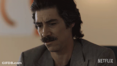 Man With Mustache Sitting In Front Of Netflix Wall GIF