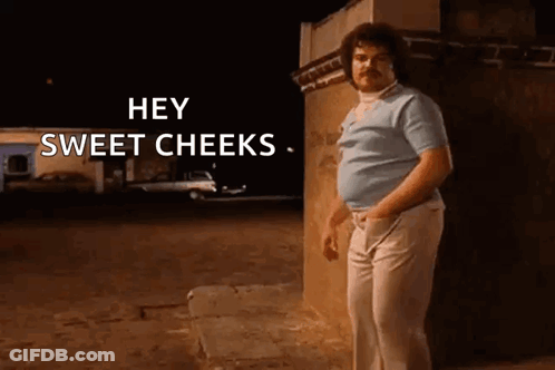 Man With Mustache Standing In Front Of Building At Night GIF