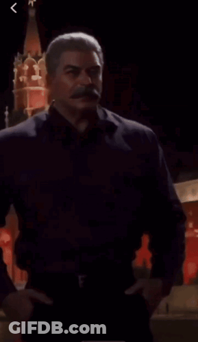 Man With Mustache Standing In Front Of Red Tower GIF