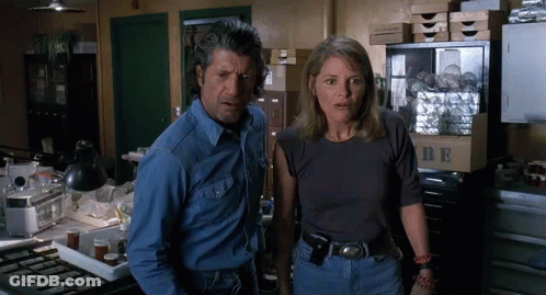 Man With Mustache Standing Next To Another Man Looking Out Window GIF