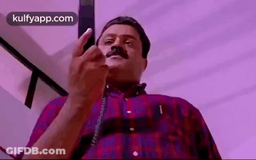 Man With Mustache Talking On Phone Pointing At Camera GIF