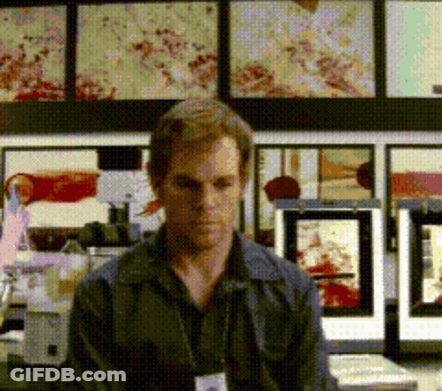 Man With Name Tag In Front Of Pictures GIF