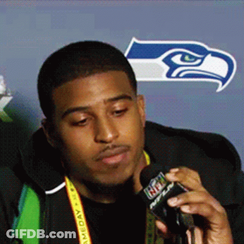 Man With NFL Lanyard Talking Into Microphone GIF