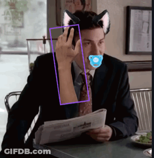 Man With Pacifier Sitting At Table With Newspaper GIF