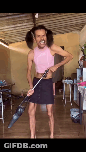 Man With Pigtails Holding Vacuum Cleaner GIF