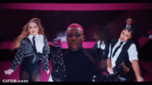 Man With Pink Hair In Front Of Female Dancers GIF