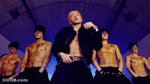Man With Pink Hair In Front Of Shirtless Men GIF