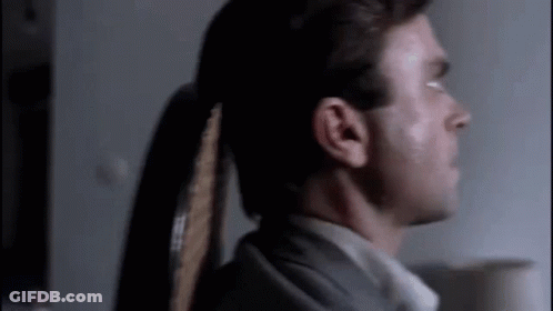 Man With Ponytail In Dark Room GIF