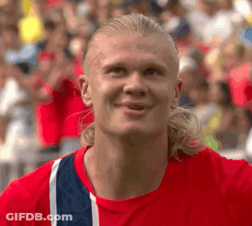 Man With Ponytail In Red And Blue Shirt GIF