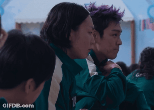 Man With Purple Hair Hugging Woman In Green Jacket GIF