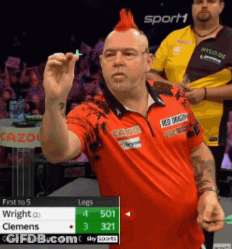 Man With Red Mohawk Holding Dart In Front Of Sport1 Sign GIF