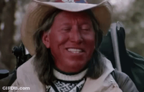 Man With Red Paint, Cowboy Hat, And Backpack GIF