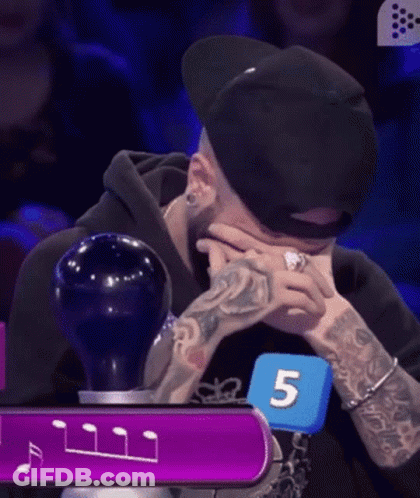 Man With Ring Sitting In Front Of Blue Number 5 GIF