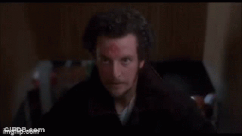 Man With Scar Standing In Dark Room GIF
