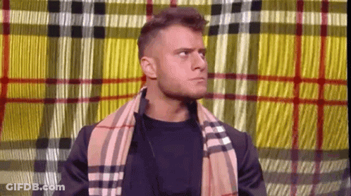 Man With Scarf And Plaid Jacket Before Plaid Curtain GIF