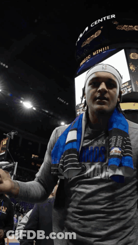Man With Scarf In Front Of Magic Win Scoreboard GIF
