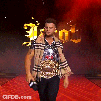 Man With Scarf On Red Carpet Holding Microphone GIF