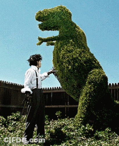 Man With Scissors Next To Dinosaur GIF