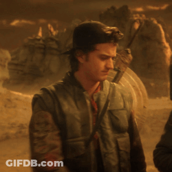 Man With Shield On Back Standing In Desert GIF