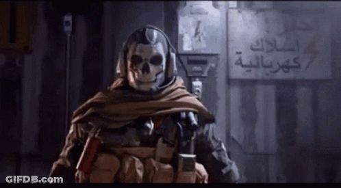 Man With Skull On Face In Front Of Wall With Arabic Writing GIF