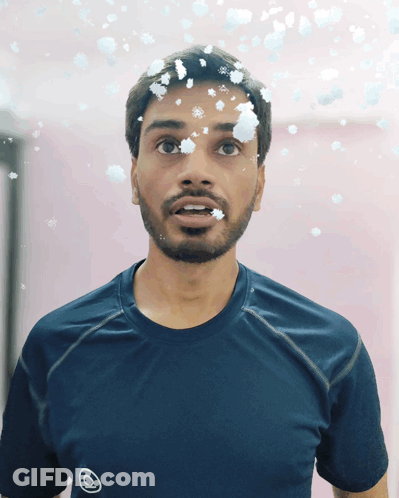 Man With Snowflakes On Face In Blue Shirt GIF