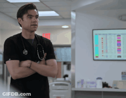 Man With Stethoscope In Front Of Exit Sign GIF