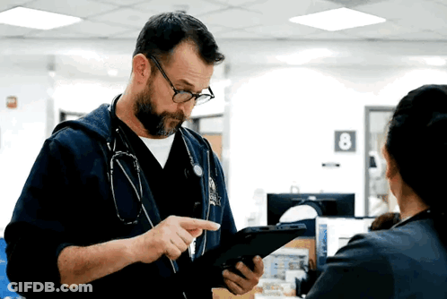 Man With Stethoscope Looking At Tablet While Woman Looks On GIF