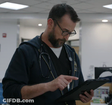 Man With Stethoscope Looking At Tablet GIF