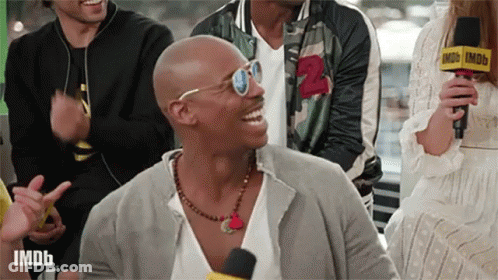 Man With Sunglasses And Necklace Laughing At Imdb Microphone GIF