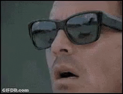 Man With Sunglasses Holding Scissors To Mouth GIF