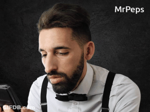 Man With Suspenders And Bow Tie Looking At Phone GIF