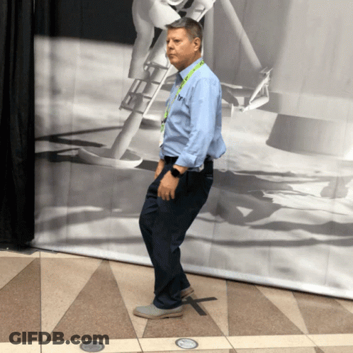 Man With T Lanyard In Front Of Black And White Picture GIF