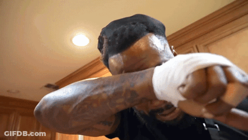 Man With Tattoo Holding Fist Up GIF