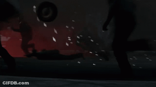 Man With Tattoo In Dark Room With Other Men GIF
