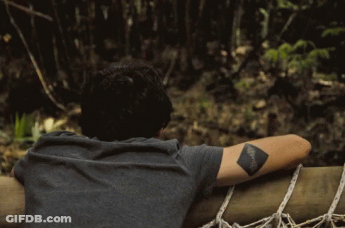 Man With Tattoo Looking Over Railing GIF