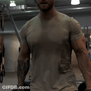 Man With Tattoo On Arm Standing In Gym GIF