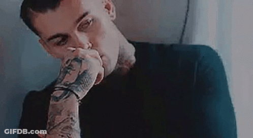 Man With Tattooed Arms Covering Mouth GIF