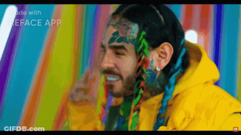 Man With Tattoos On Face In Yellow Jacket GIF