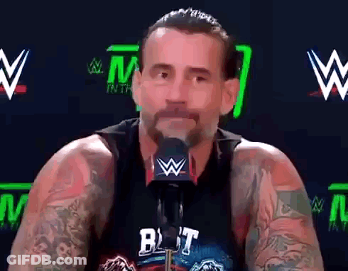 Man With Tattoos Talking Into Microphone Wearing But Shirt GIF