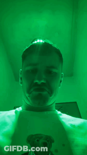 Man With Teddy Bear Shirt Taking Selfie In Green Room GIF