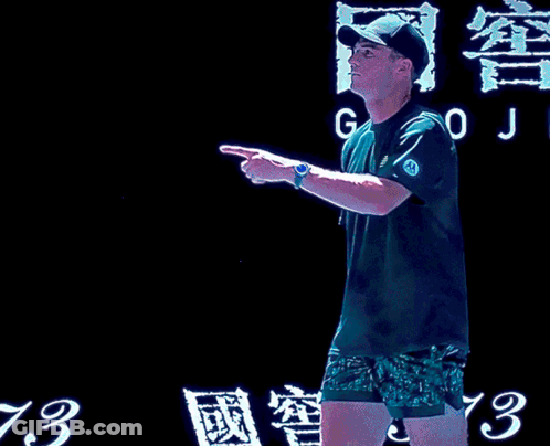 Man With Tennis Racquet And Woman In Green Dress GIF
