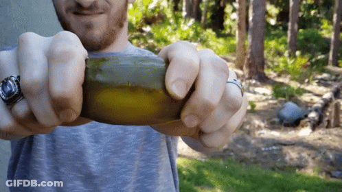 Man With Watch And Ring Holding Green Object GIF