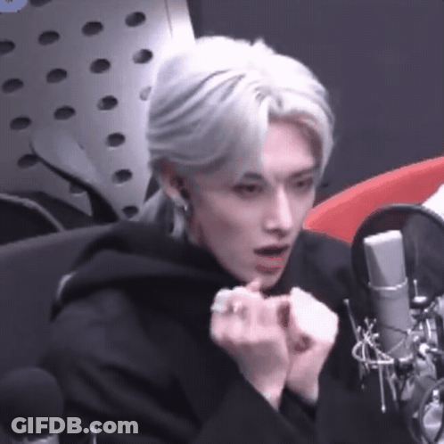 Man With White Hair Sitting At Microphone In Studio GIF