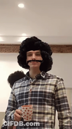 Man With Wig And Mustache Holding Cup GIF