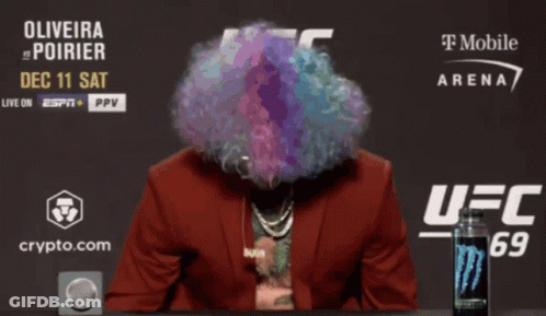 Man With Wig And Sunglasses In Front Of UFC Sign GIF