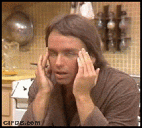 Man With Wig And Sunglasses Watching Man In Headphones GIF