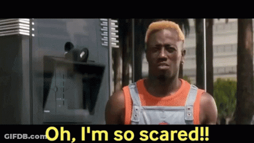 Man With Yellow Hair Standing In Front Of Scared Sign GIF