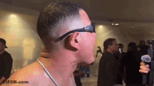 Man Without Shirt Holding Microphone In Front Of Crowd GIF